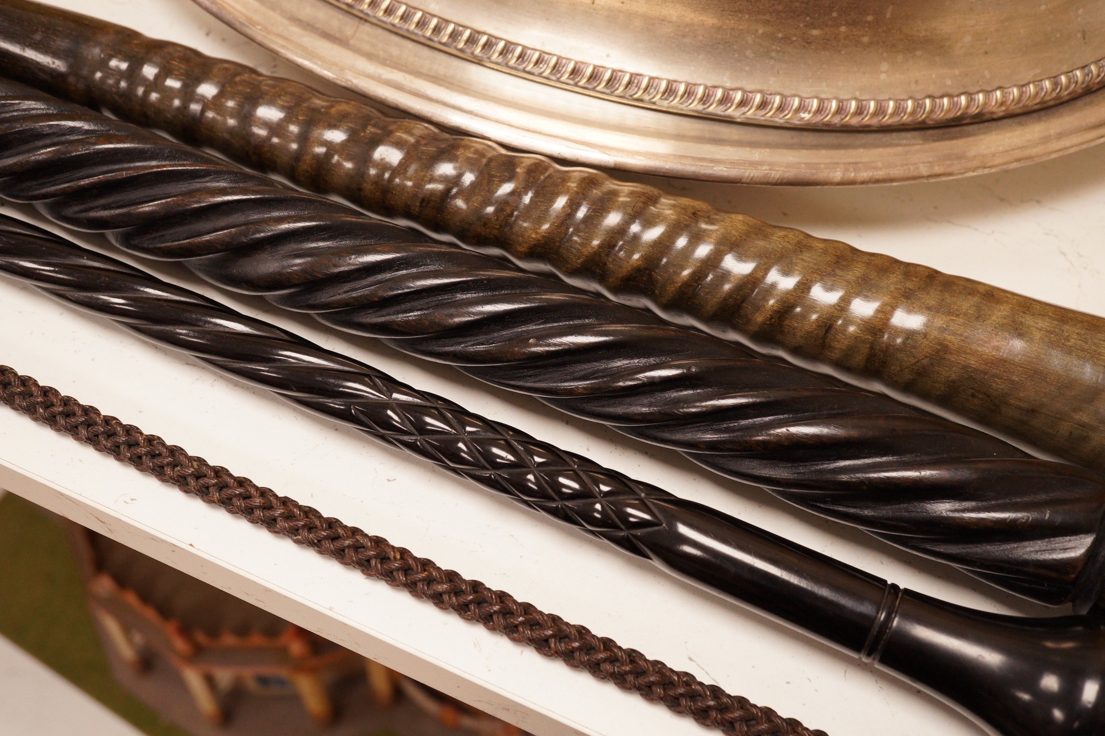 Four assorted canes to include a tapering horn example, a woven example, etc